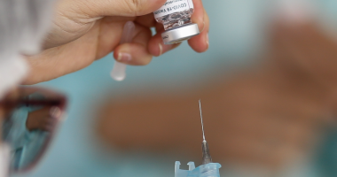 enfermeira manipula ampola de vacina